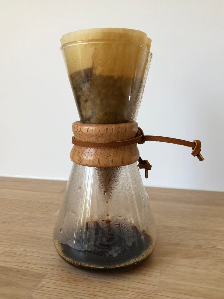 A Chemex coffeemaker with filter and dripping coffee